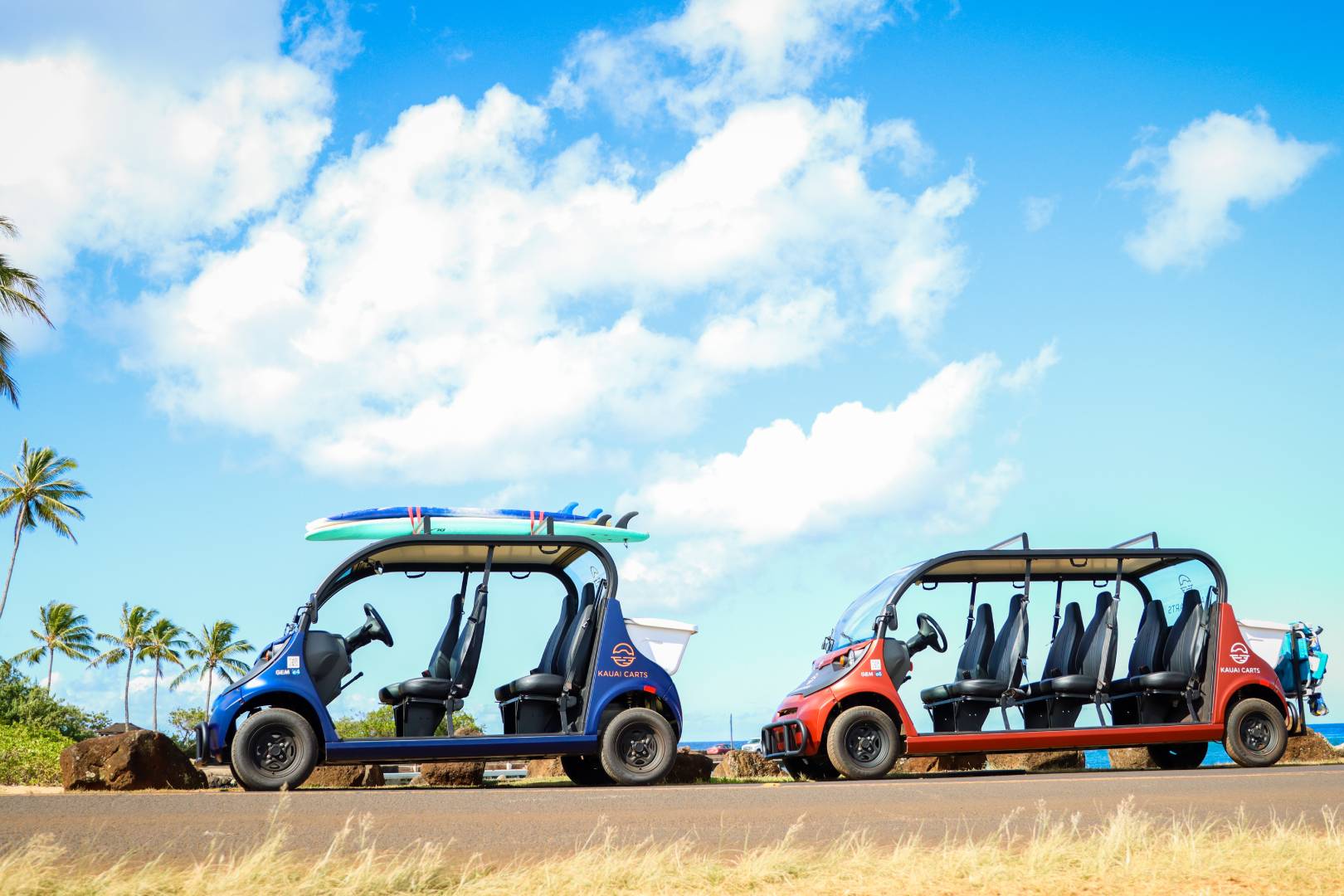 Two small cars with surfboards on the back of them.