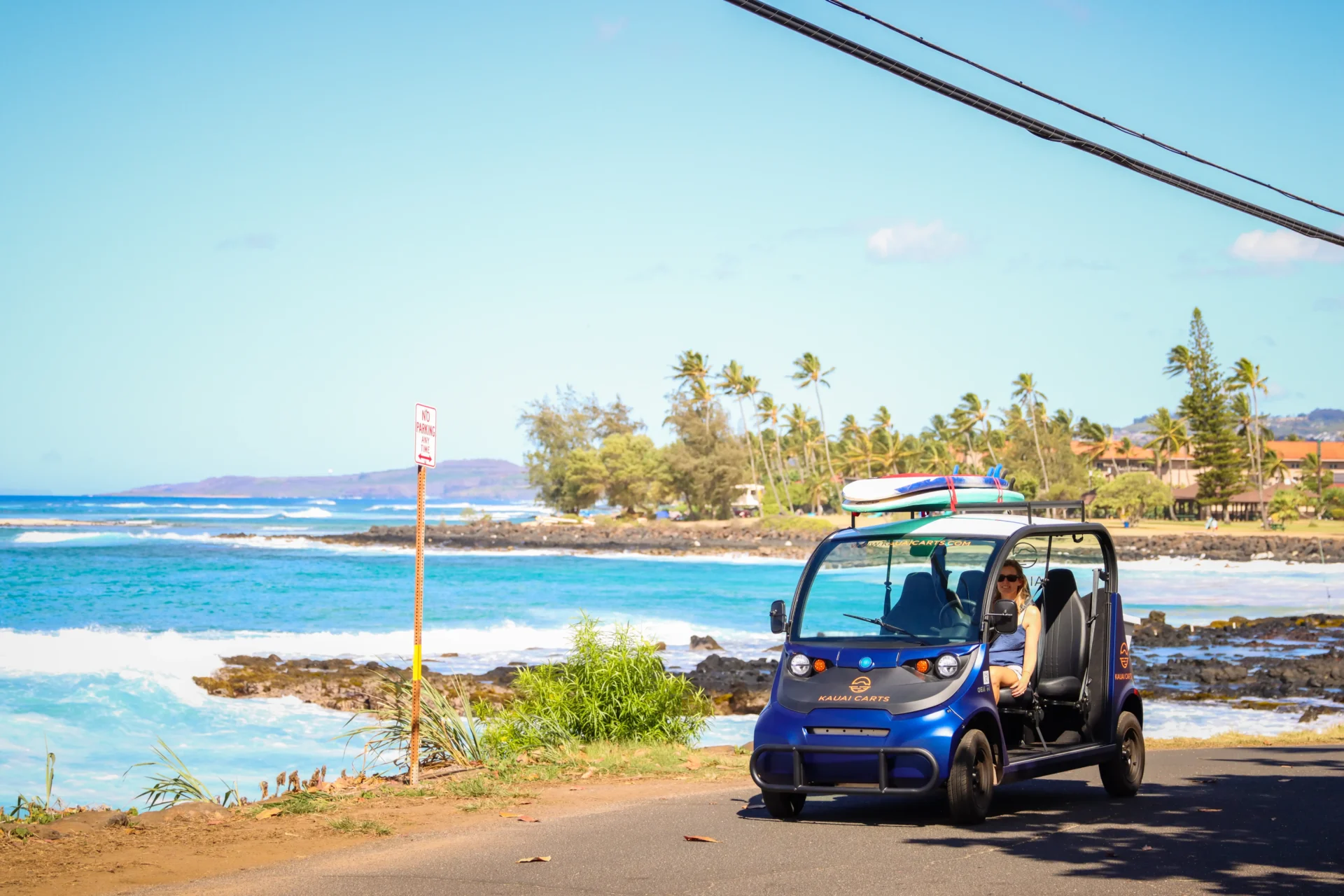 A blue car parked on the side of a road.