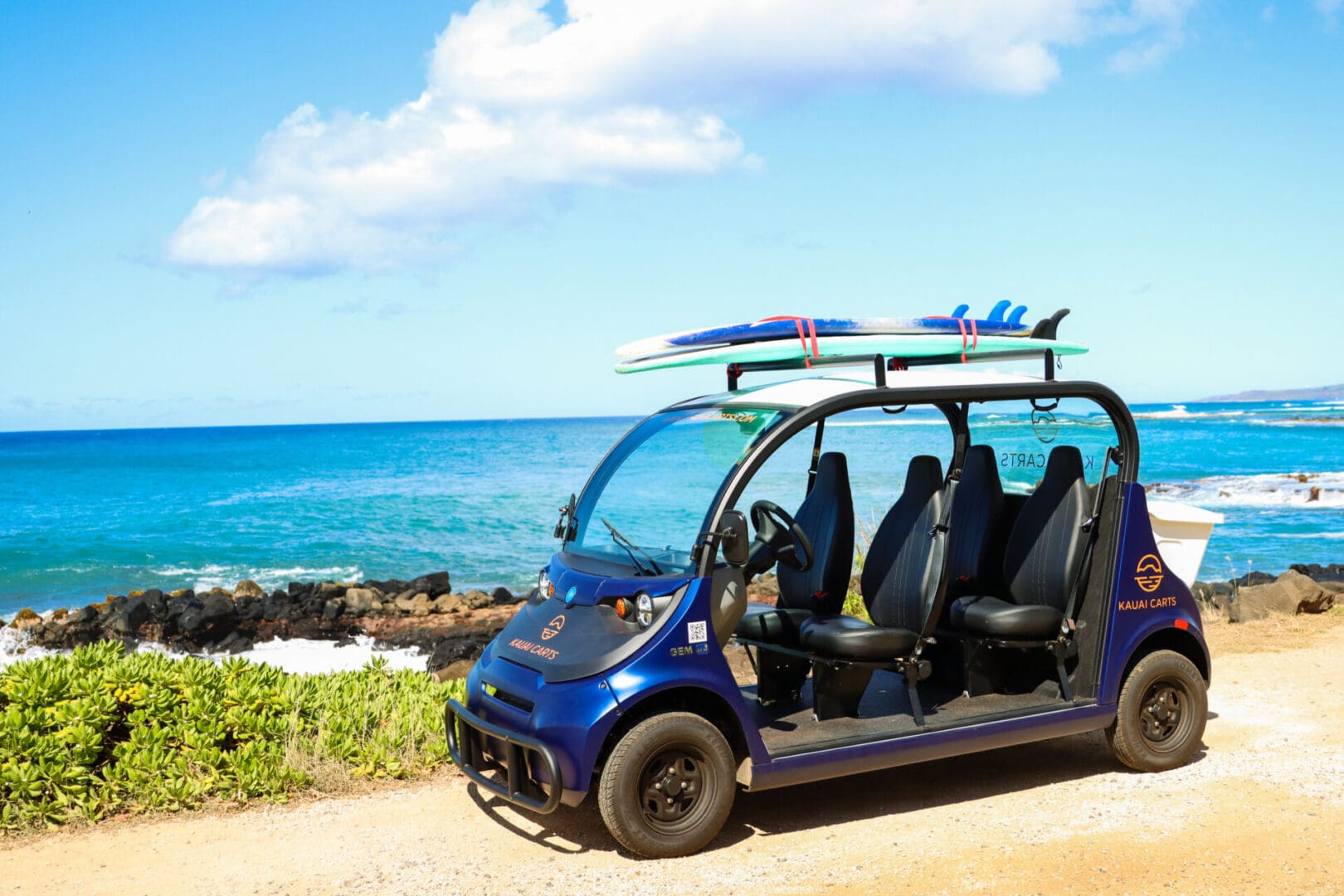 A blue car with four seats and a surfboard on top.