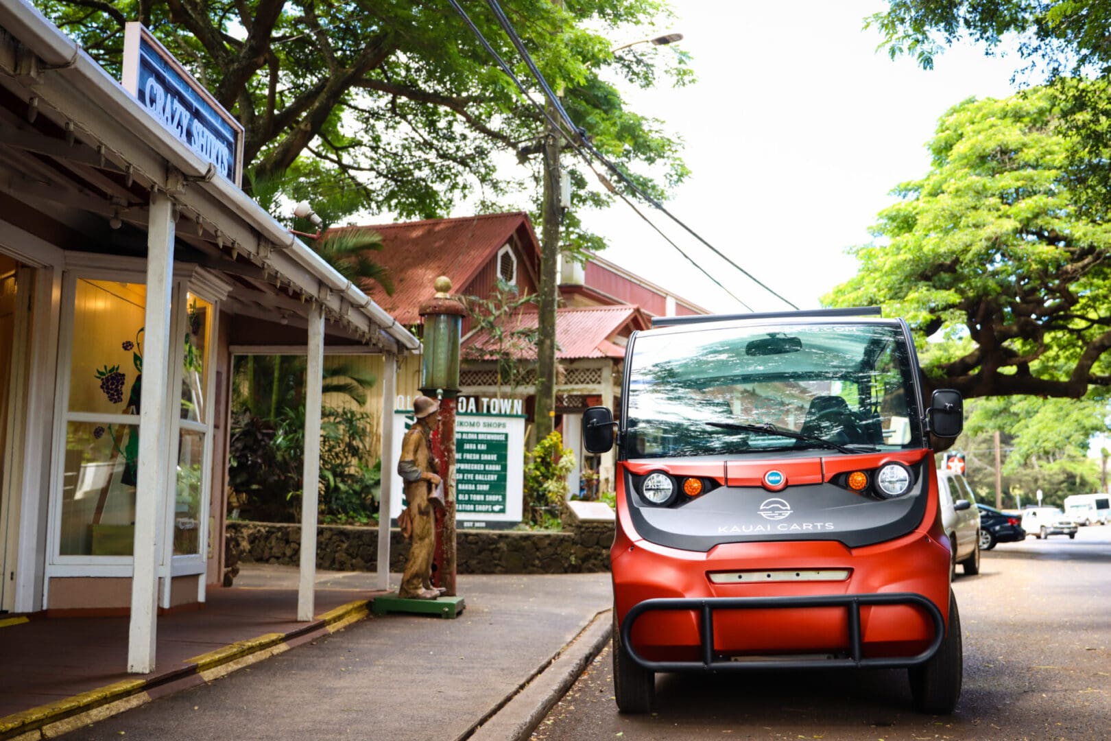 A small red car parked on the side of a road.